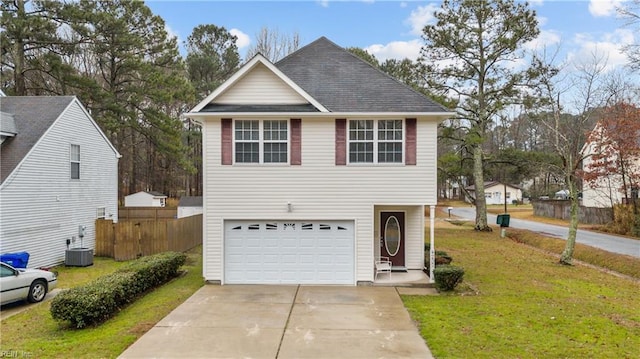 view of front of home with cooling unit, a garage, and a front yard