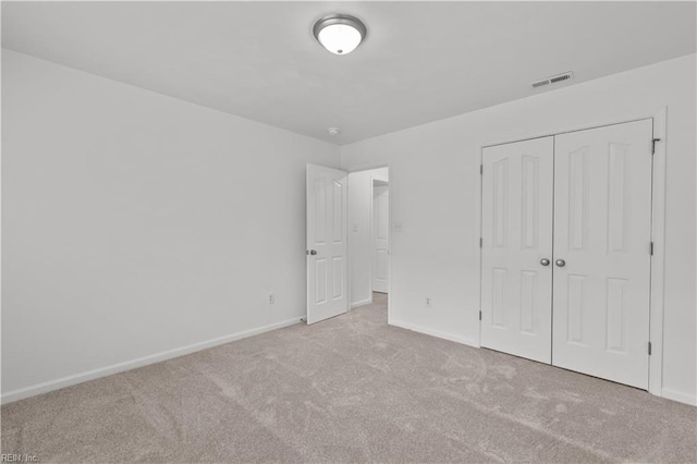 unfurnished bedroom featuring a closet and light carpet