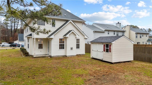 rear view of property featuring a storage unit and a yard