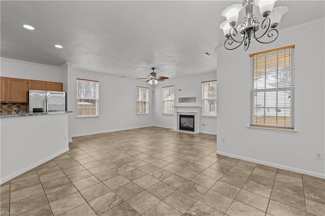 unfurnished living room with crown molding, light tile patterned floors, and ceiling fan with notable chandelier