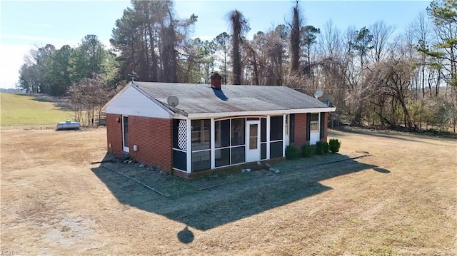 view of outdoor structure featuring a sunroom and a yard