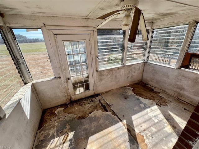 unfurnished sunroom with ceiling fan