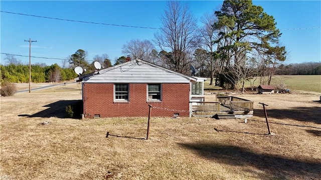 view of side of property featuring a wooden deck and a lawn