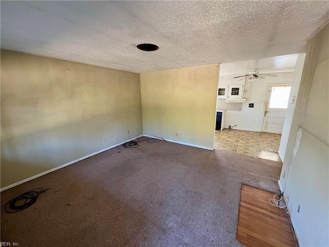 spare room with ceiling fan, carpet flooring, and a textured ceiling