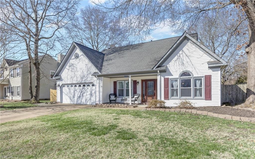 view of front of property featuring a porch, a garage, and a front yard