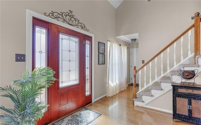 foyer featuring a high ceiling, a wealth of natural light, and light hardwood / wood-style floors