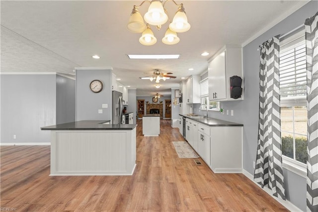 kitchen featuring stainless steel refrigerator with ice dispenser, sink, pendant lighting, ceiling fan, and white cabinets