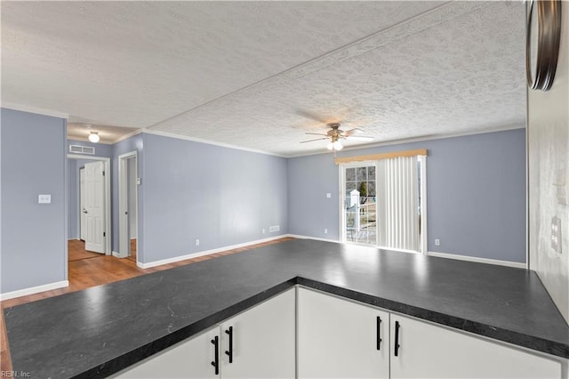 interior space featuring ceiling fan, crown molding, light hardwood / wood-style flooring, and a textured ceiling