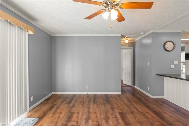 unfurnished living room with dark wood-type flooring, ceiling fan, crown molding, and a textured ceiling