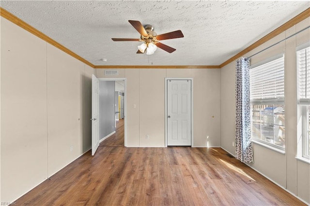 unfurnished bedroom with crown molding, ceiling fan, hardwood / wood-style flooring, and a textured ceiling