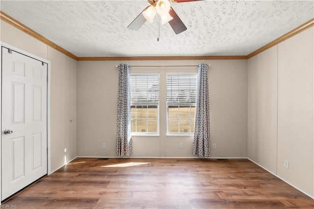 empty room featuring ornamental molding, ceiling fan, a textured ceiling, and dark hardwood / wood-style flooring