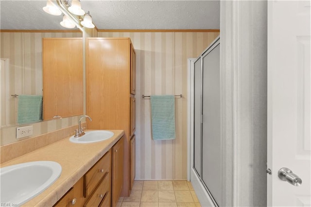 bathroom with tile patterned flooring, vanity, a textured ceiling, and walk in shower