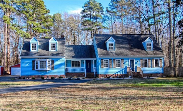 cape cod home featuring a garage, an outdoor structure, a front lawn, and a porch