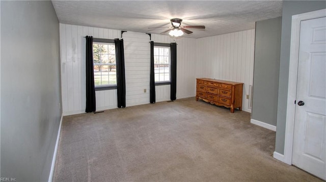 carpeted spare room with ceiling fan and a textured ceiling