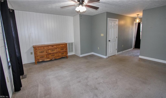 carpeted spare room with ceiling fan and a textured ceiling