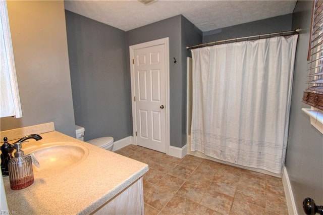 bathroom featuring vanity, toilet, and curtained shower