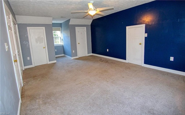 spare room featuring ceiling fan, light colored carpet, and a textured ceiling