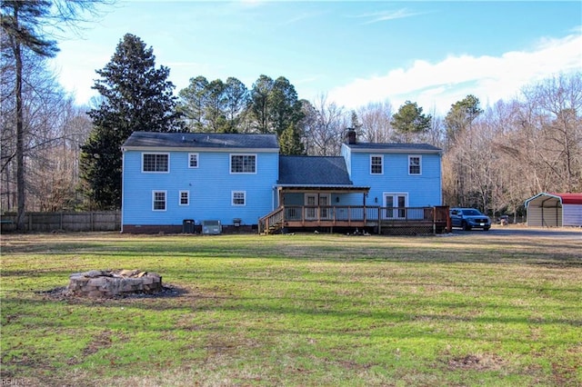 rear view of property featuring a wooden deck, an outdoor fire pit, a yard, and central AC