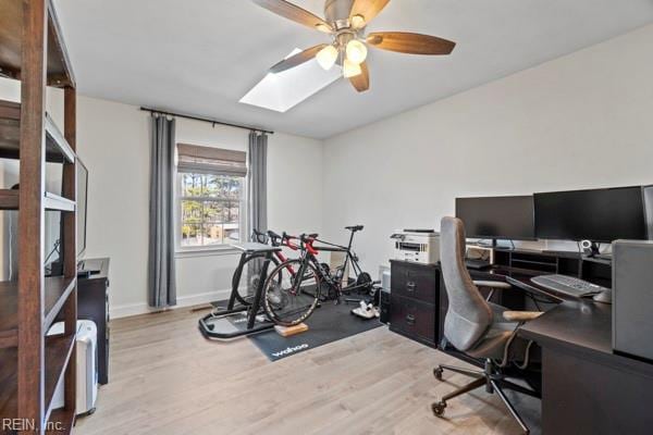 office with a skylight, ceiling fan, and light wood-type flooring