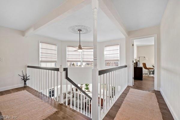 hallway with dark wood-type flooring and beam ceiling