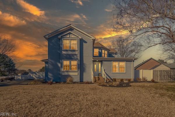 back house at dusk featuring a yard