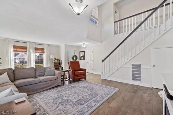 living room with a towering ceiling and hardwood / wood-style floors