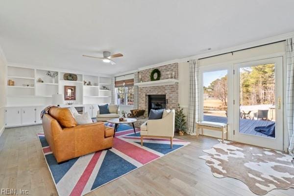 living room with built in shelves, light hardwood / wood-style floors, and a wealth of natural light