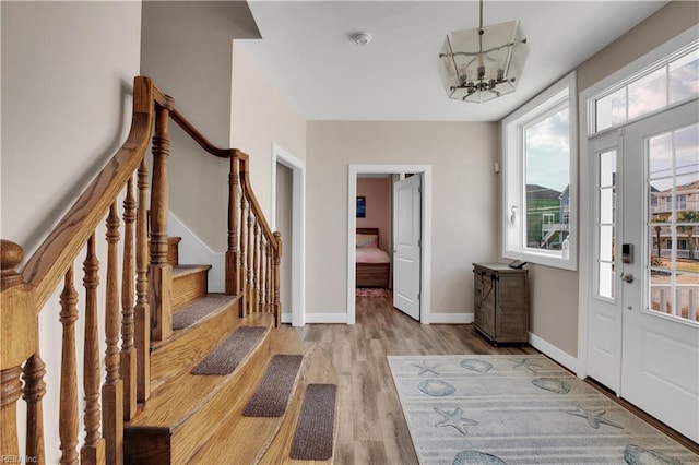 foyer entrance with a notable chandelier and light wood-type flooring