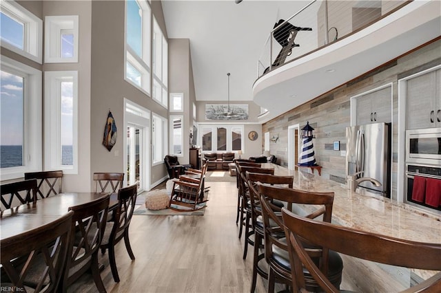 dining area with a high ceiling and light wood-type flooring