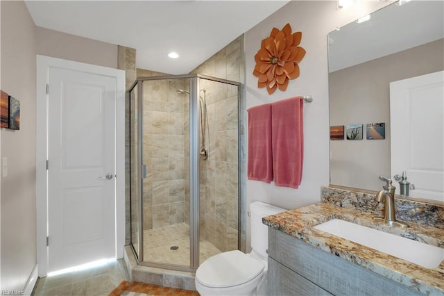 bathroom with a shower with door, vanity, and toilet