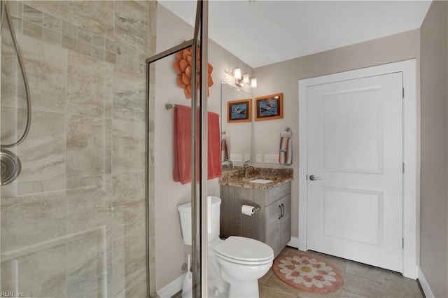 bathroom with tile patterned flooring, vanity, a shower with shower door, and toilet