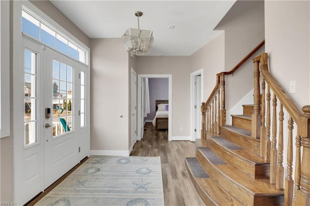 foyer entrance with hardwood / wood-style flooring and a notable chandelier