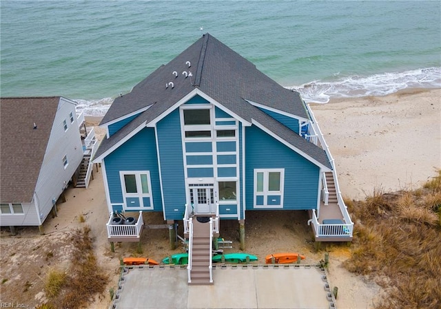 back of house featuring a water view and a view of the beach