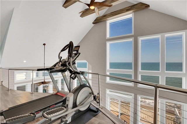 exercise area with high vaulted ceiling and a water view