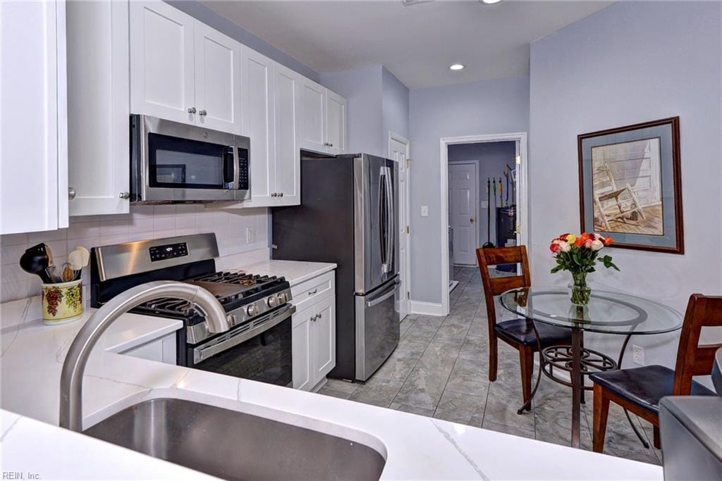 kitchen featuring white cabinetry, sink, decorative backsplash, and appliances with stainless steel finishes