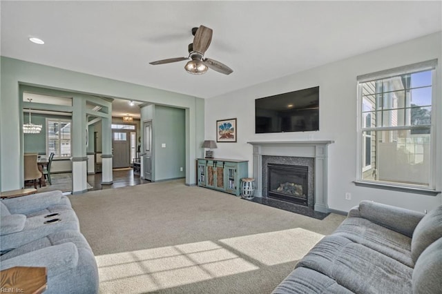 living room featuring a fireplace, carpet floors, and ceiling fan