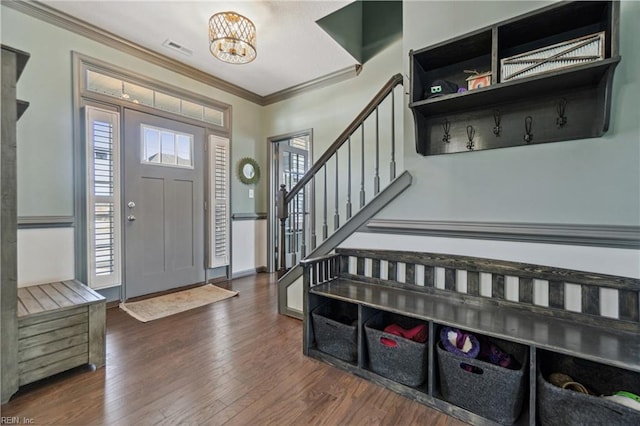 foyer with ornamental molding, a notable chandelier, and dark hardwood / wood-style flooring