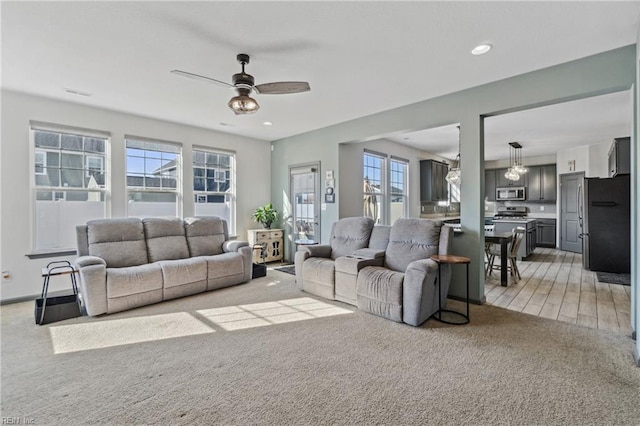 living room featuring ceiling fan and light carpet