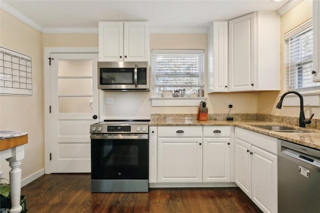 kitchen featuring white cabinetry, appliances with stainless steel finishes, crown molding, and sink