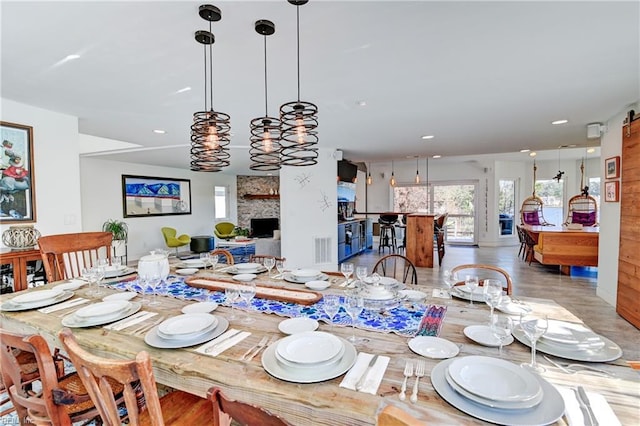 dining space with a fireplace and light hardwood / wood-style floors