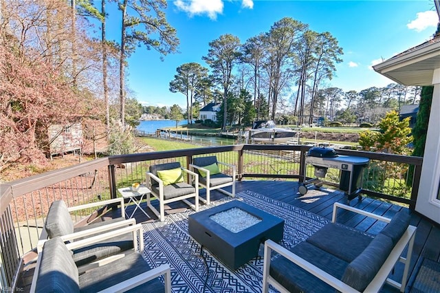 wooden terrace with a water view and a fire pit