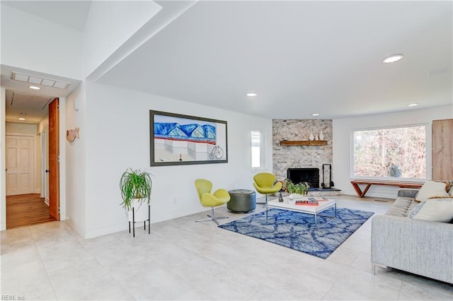 living room featuring a wealth of natural light and a large fireplace