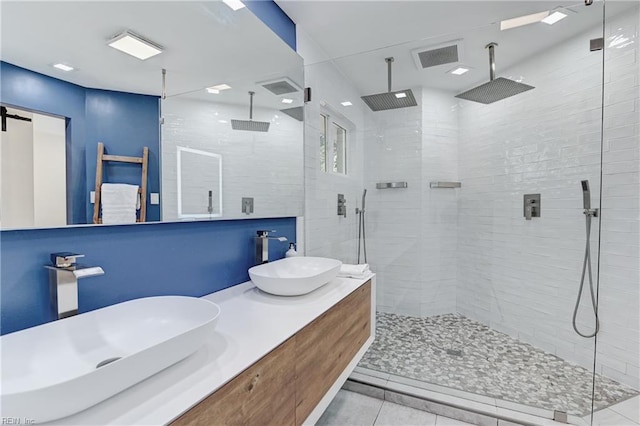 bathroom featuring a tile shower and vanity