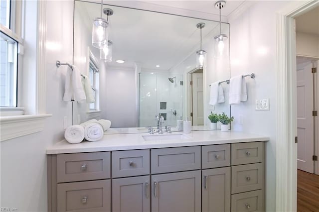 bathroom featuring an enclosed shower, vanity, wood-type flooring, and ornamental molding