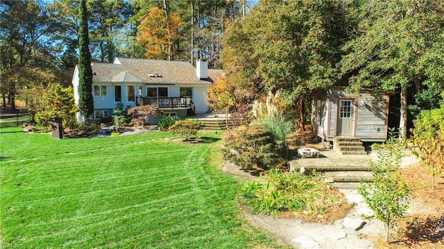 exterior space with a wooden deck, an outdoor structure, and a front lawn