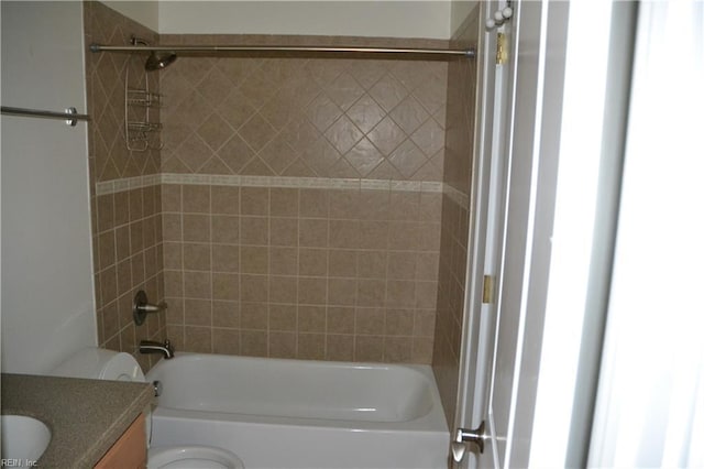 full bathroom with vanity, tiled shower / bath combo, and toilet