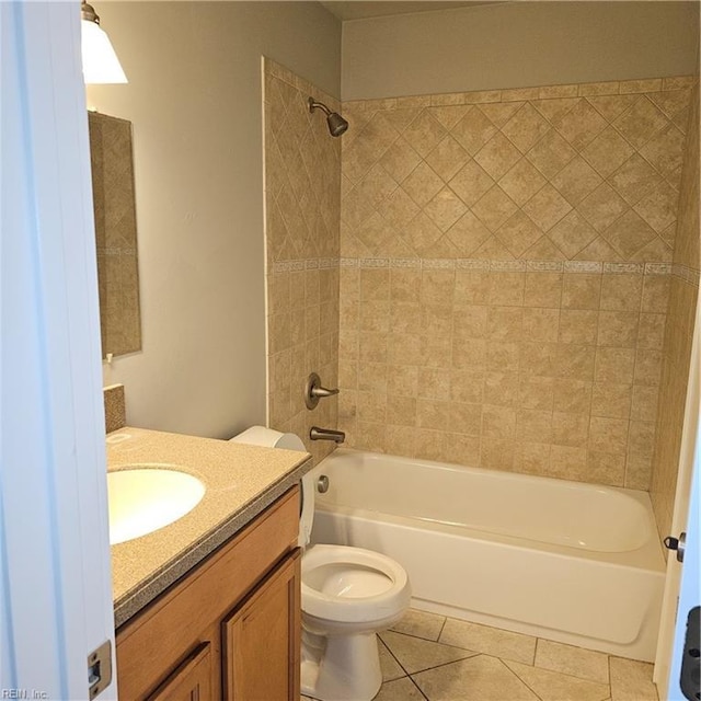 full bathroom featuring tiled shower / bath combo, vanity, tile patterned floors, and toilet