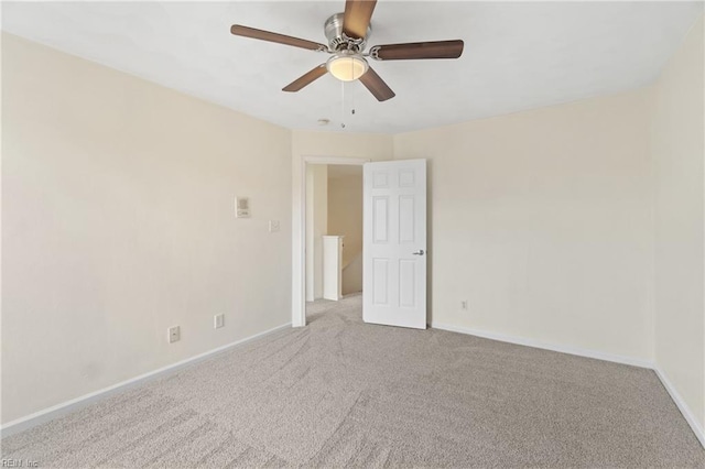 carpeted spare room featuring ceiling fan