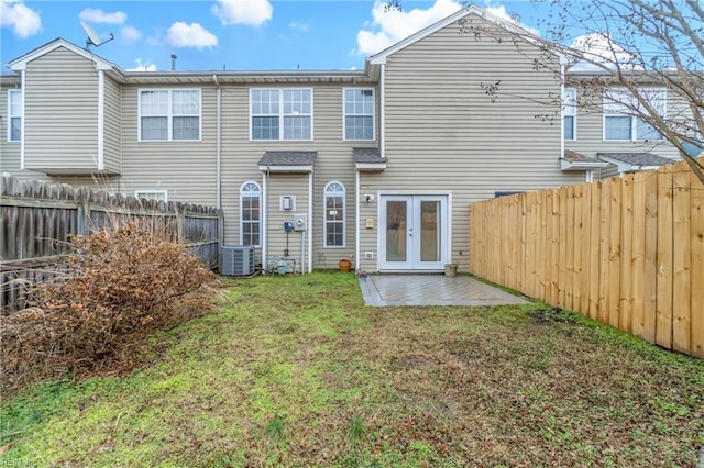 back of property with a patio, a lawn, central AC unit, and french doors