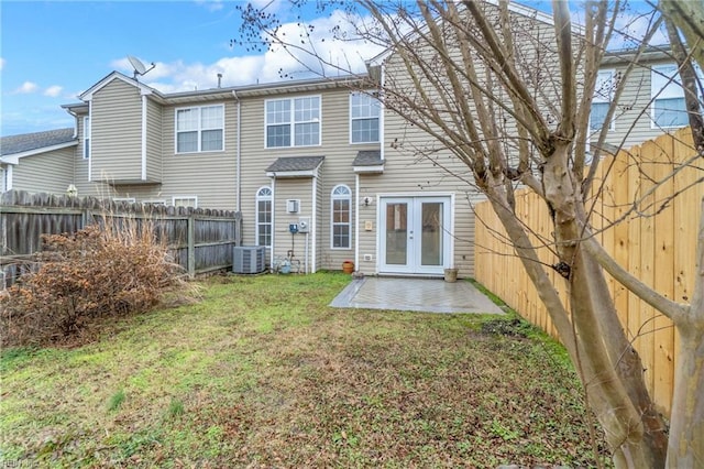 back of property with cooling unit, a lawn, a patio area, and french doors